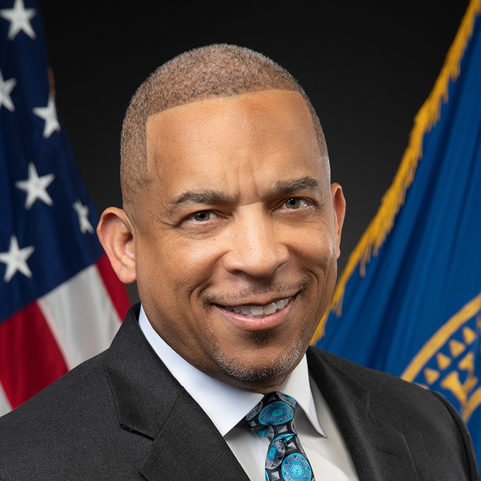 Office of the Chief Operating Officer Robin Bailey Jr., MA. There is an American Flag and another flag in the background.