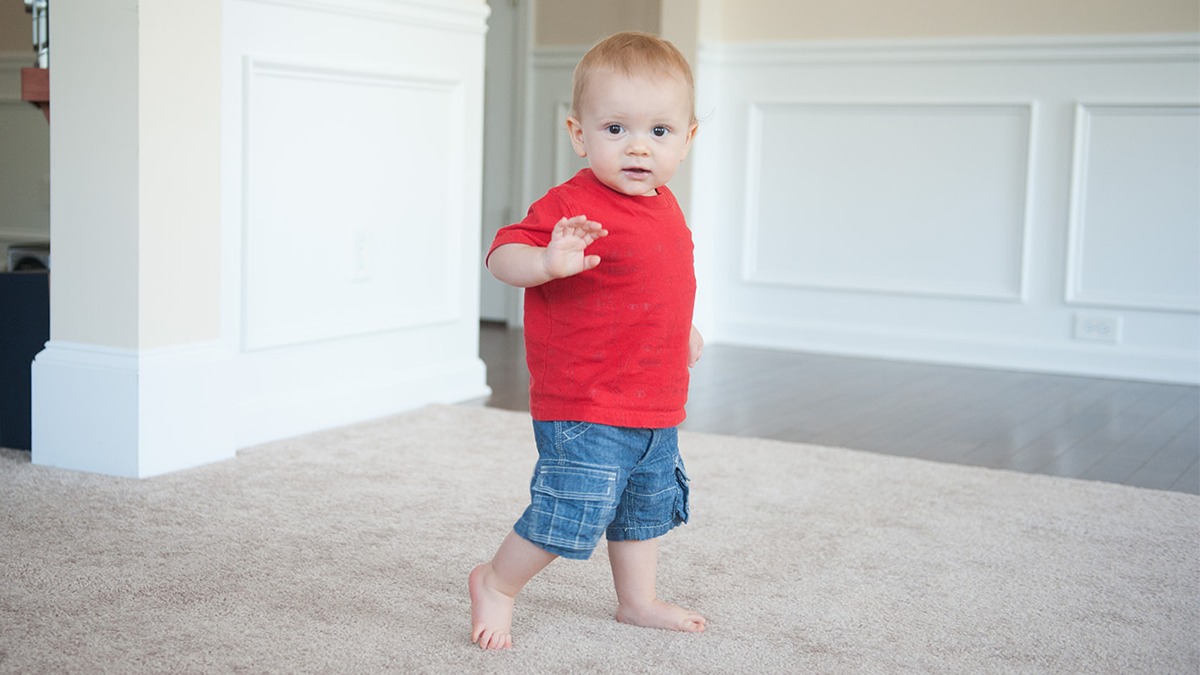 child walking and waving