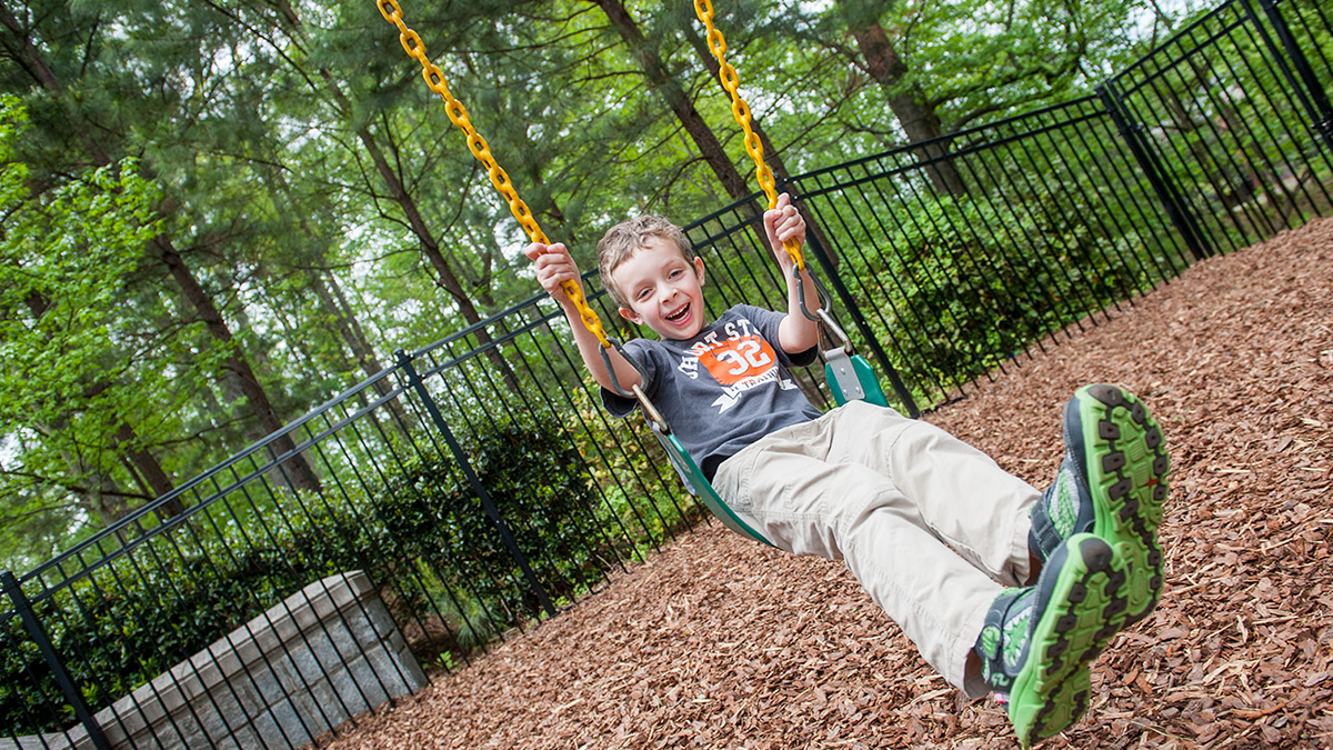 child swinging on swing smiling