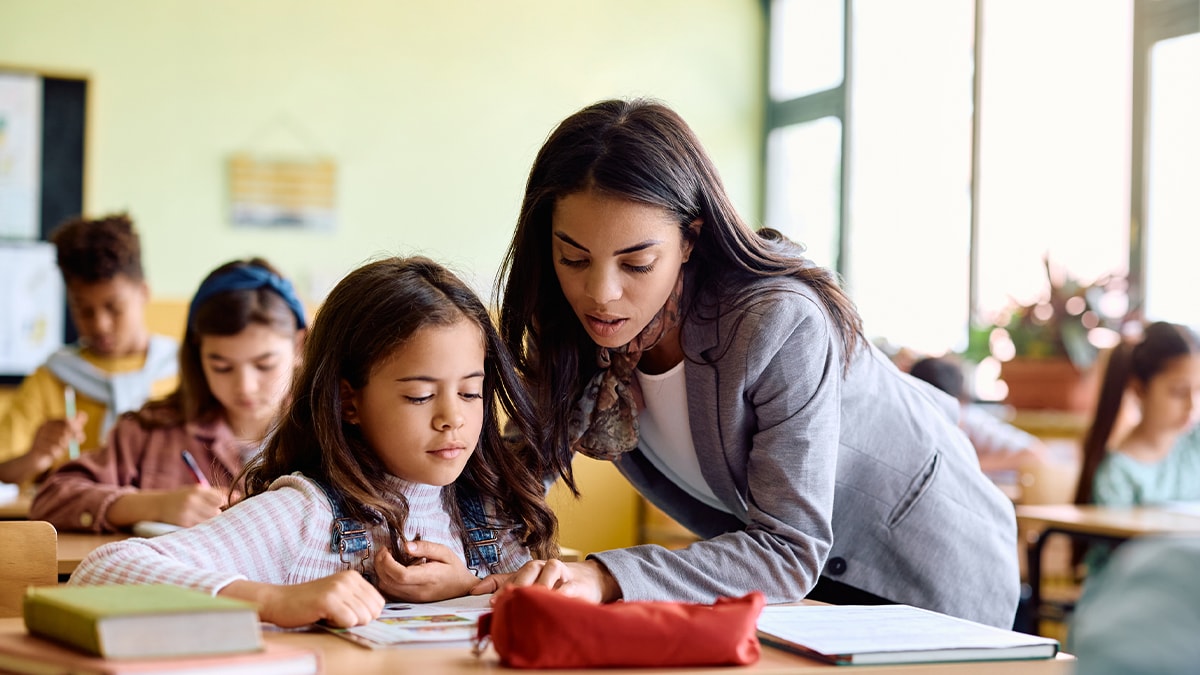 — title missing — A teacher is helping a student in the classroom