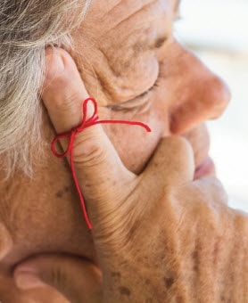cognitive-decline-2 Elder woman with red string on right index finger