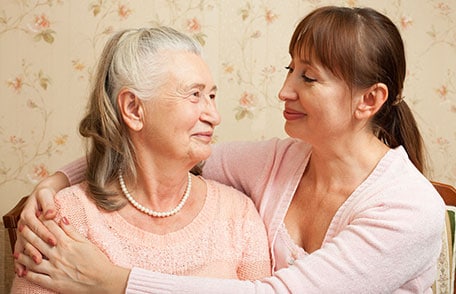 Adult woman hugging mother and smiling