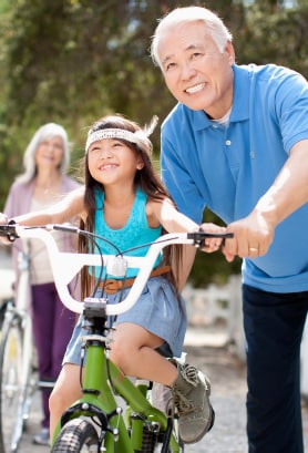 Grandparent with a granddaughter on her bike