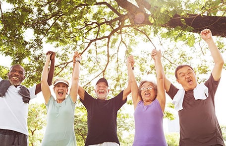 Group of senior adults holding hands and raising arms