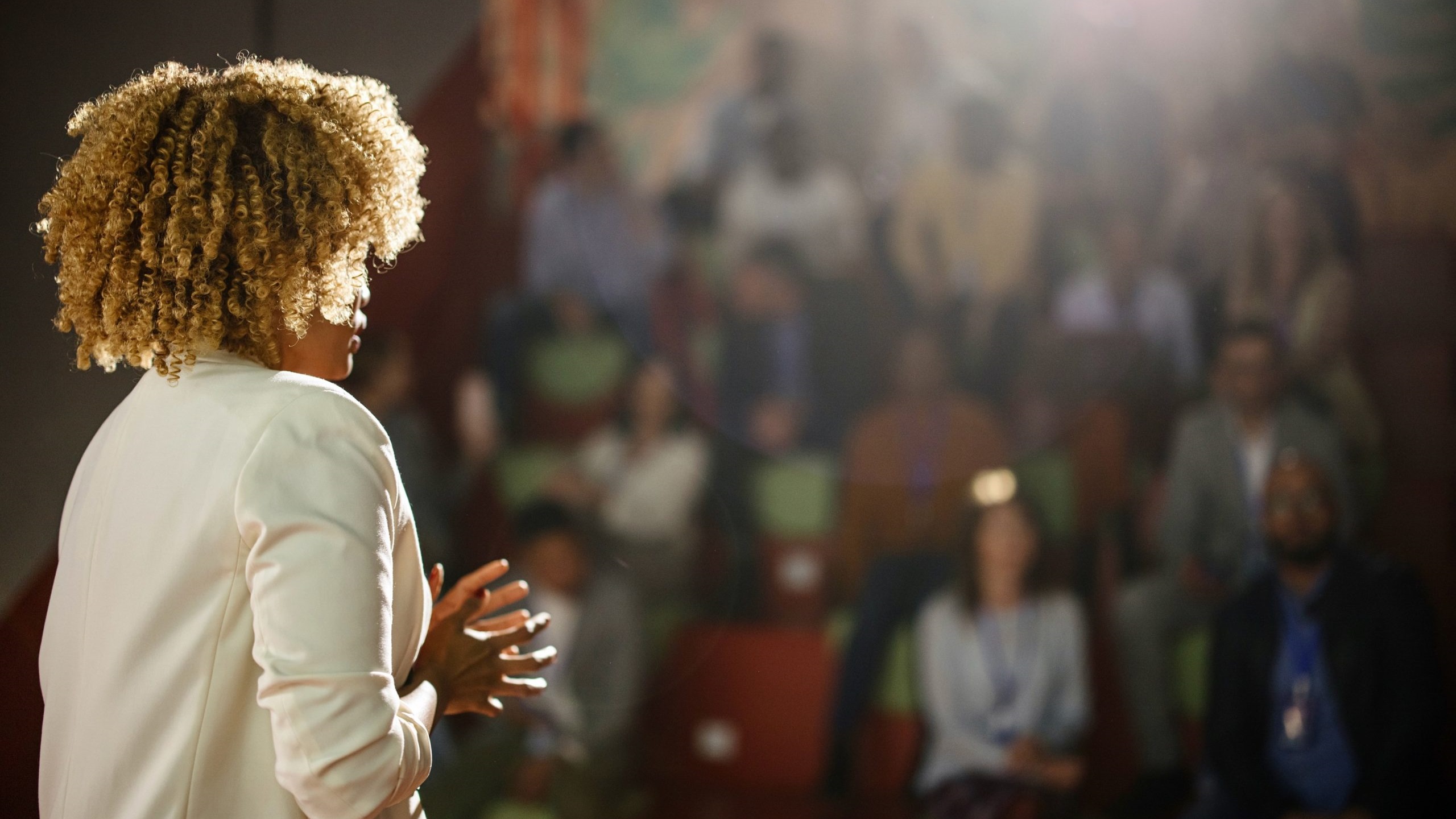 woman in front of audience Woman presenting in front of audience