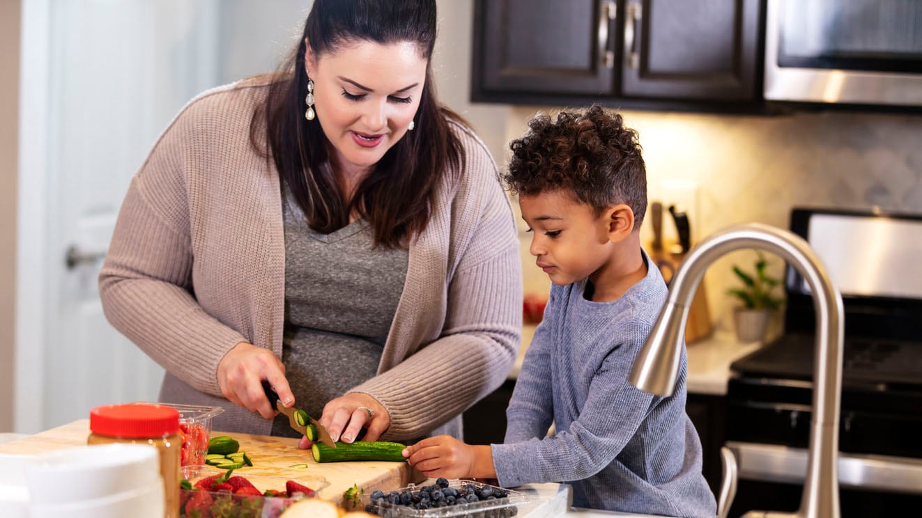 Mother and young son preparing vegetables in kitchen Mother and young son preparing vegetables in the kitchen