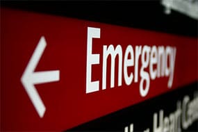 A red emergency sign with an arrow pointing left