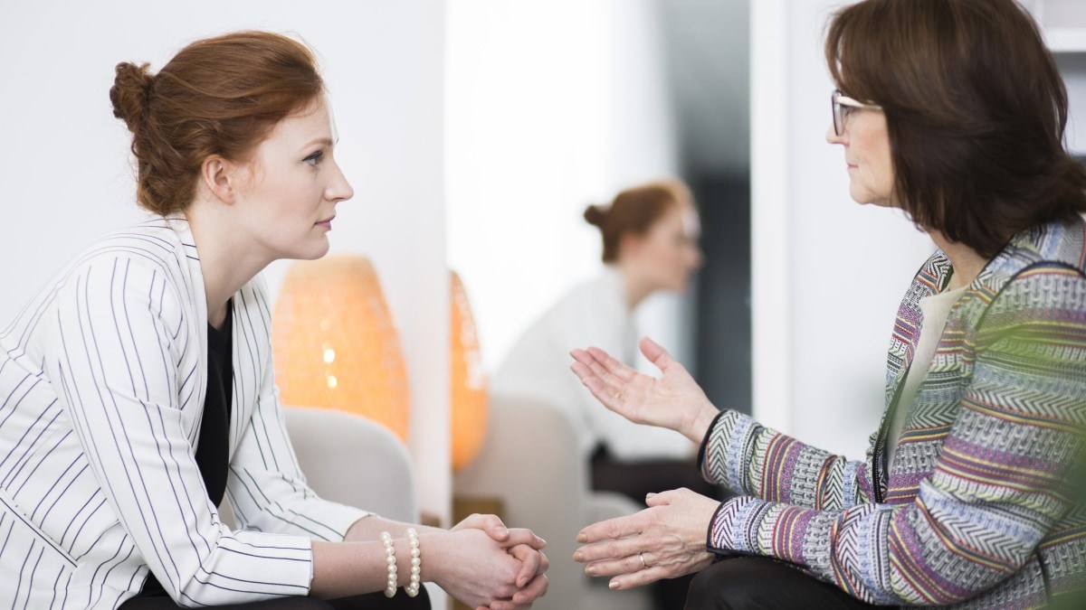 Photo of a patient navigator talking to a patient