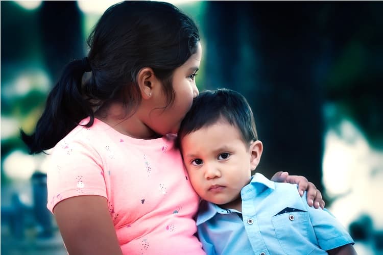 A girl comforts her younger brother