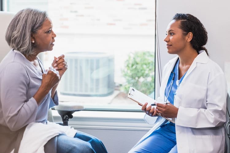 Photo of a patient talking to her doctor.