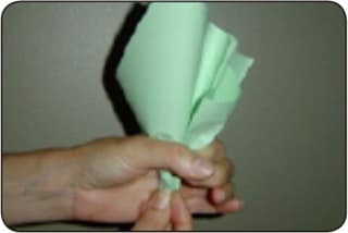 Figure 2 A person folds sheets of green paper to form a paper cabbage