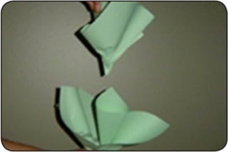 Figura 3 Una persona dobla hojas de papel verde para formar un repollo de papel