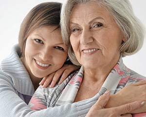 Photo of a granddaughter leaning over her grandmother
