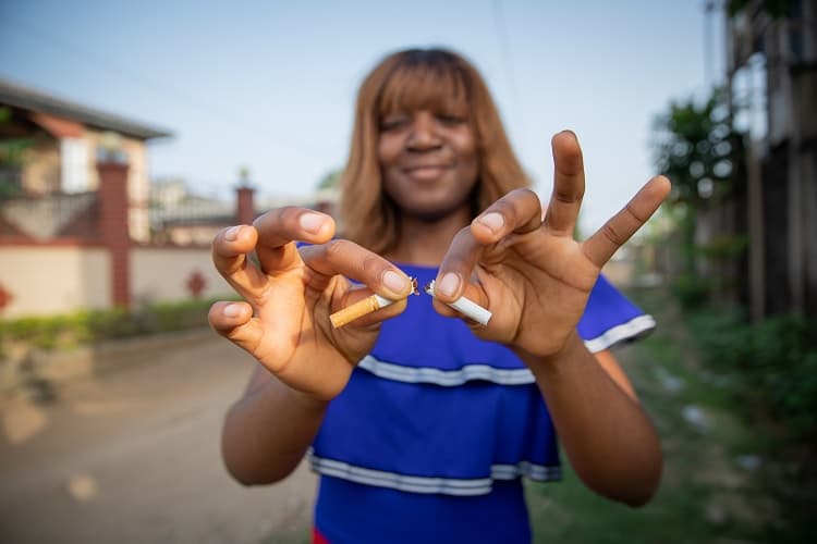 Foto ode una mujer afroamericana rompiendo un cigarillo
