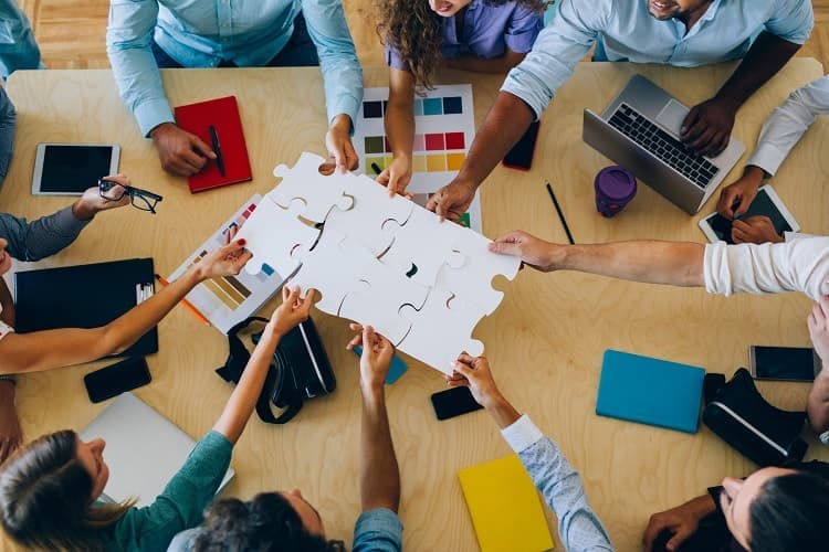 A group of racially diverse people puts a puzzle together