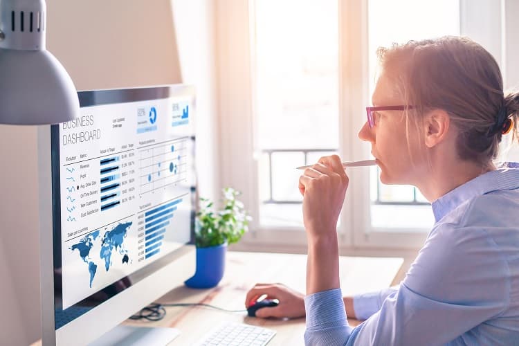 Photo of a woman looking at statistics on a computer