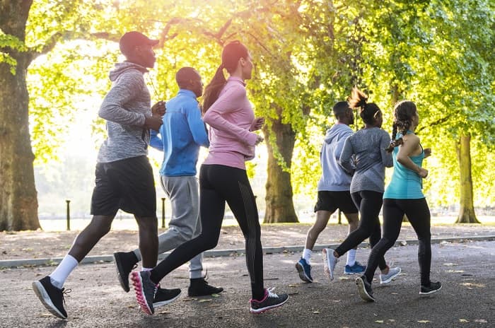 A group of people jogging in a park.