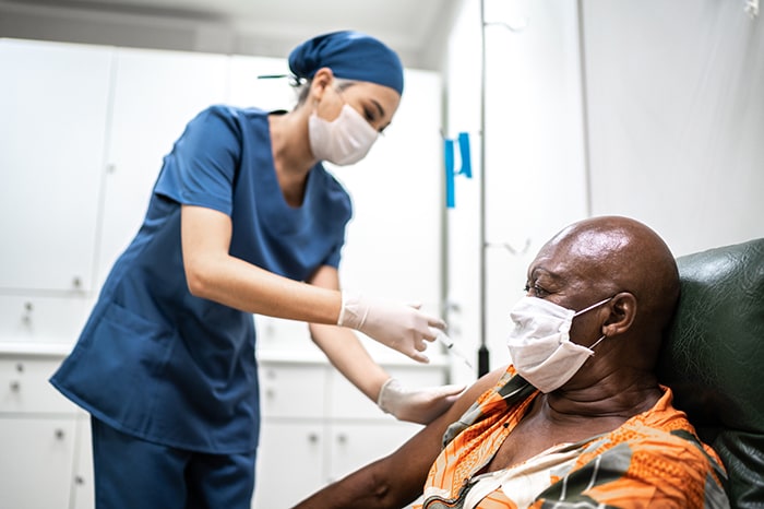 Photo of a nurse providing a vaccine to a cancer patient