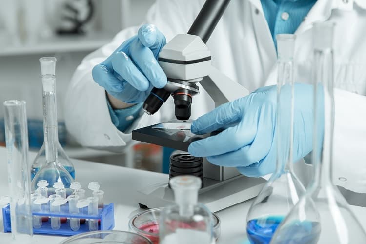 Photo of a pathologist examining a specimen under a microscope