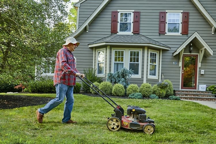 Photo of a man mowing his lawn
