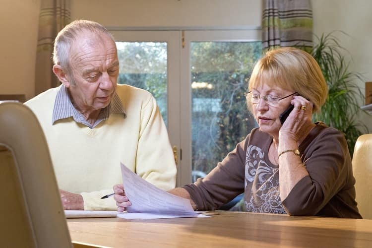 Photo of a woman holding a bill and talking on the telephone