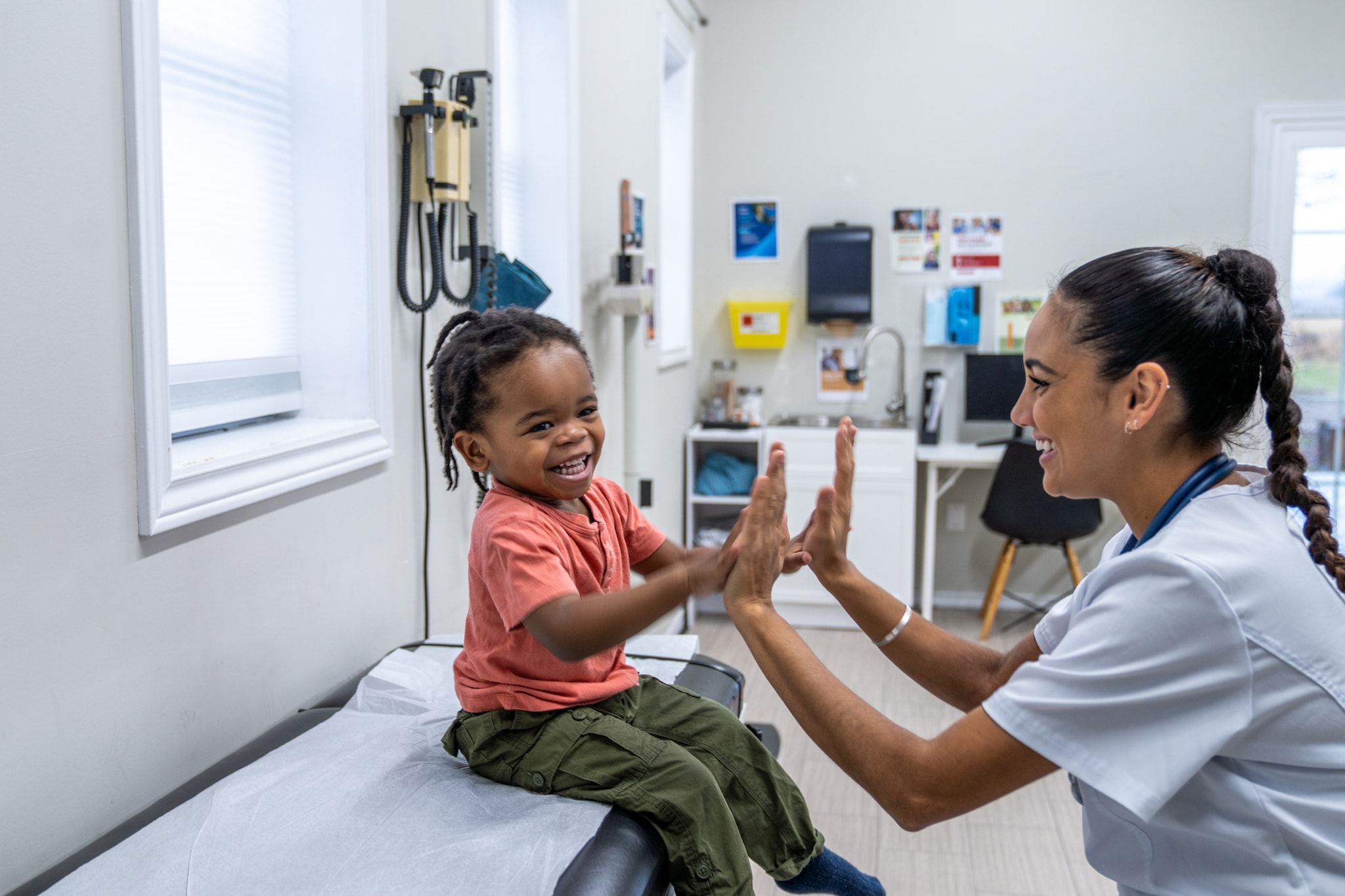 Smiling girl examined by doctor