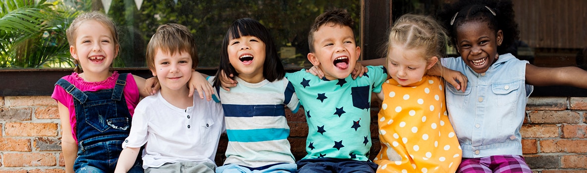 group-of-young-girls Diverse kids sitting and laughing together