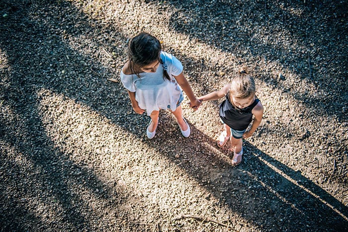 Two girls holding hands on playground Two girls holding hands on playground