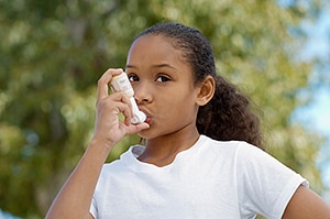 effects_air_pollution.jpg Girl (7-9) using inhaler, outdoors - Air Pollution
