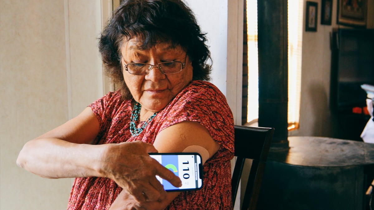 Senior Woman Checking Blood Glucose Level on an App Una mujer embarazada pensativa mirando por la ventana.