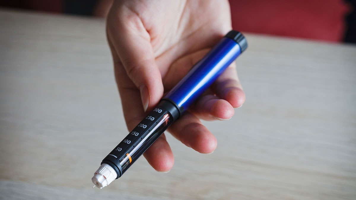 Woman holding pen injector Woman holding pen injector