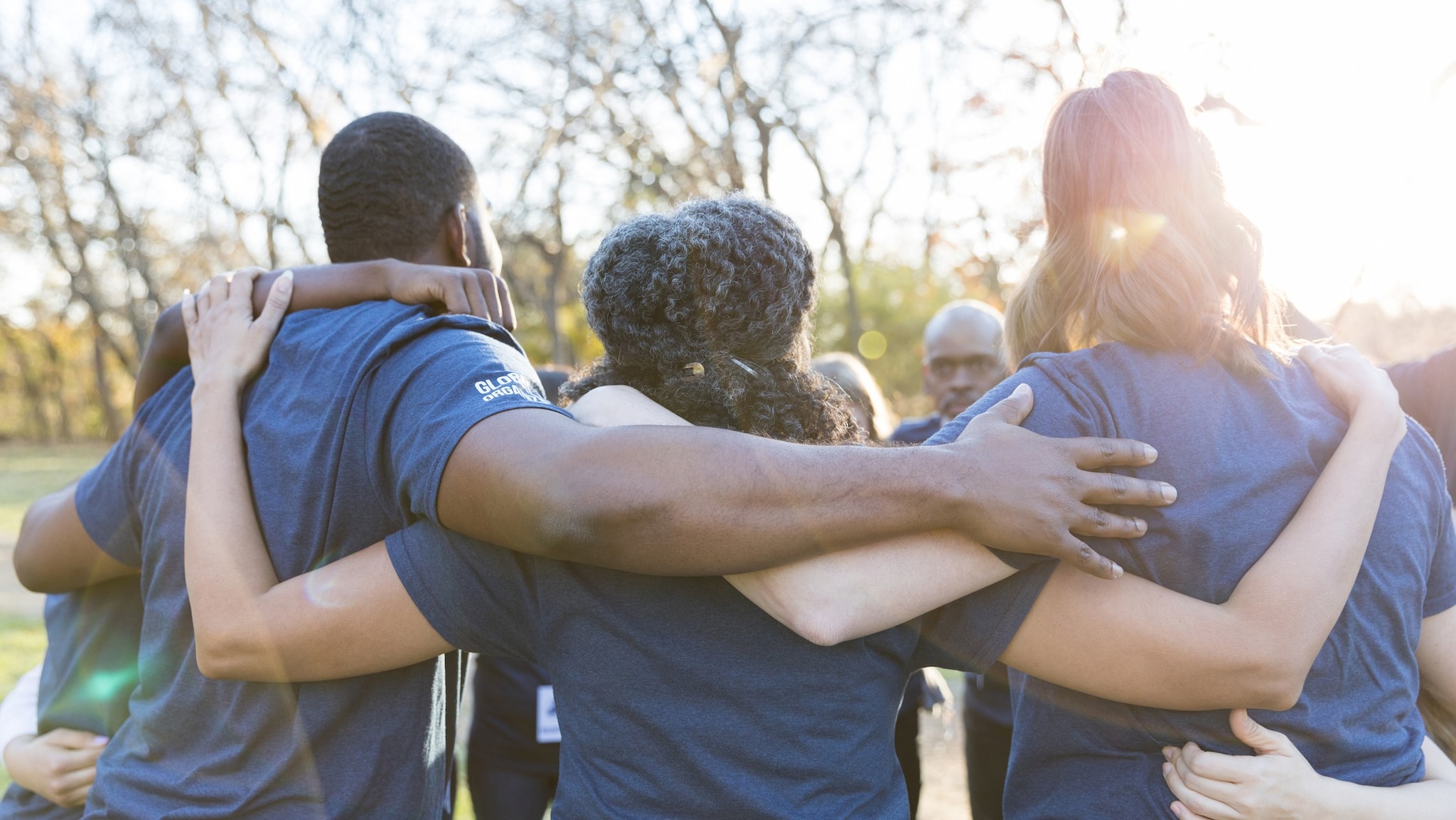 — title missing — A group of volunteers embracing outside