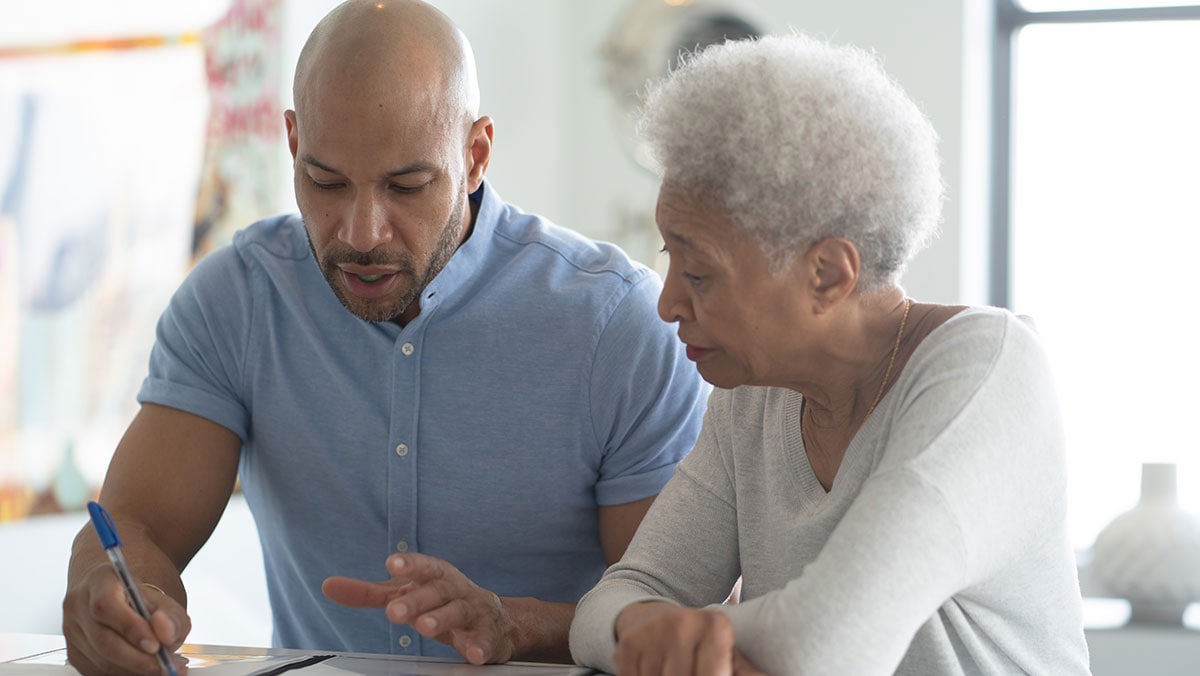 GettyImages-1184717555-cr man working with elderly woman