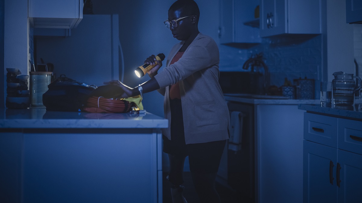 A woman using a flash light in the kitchen