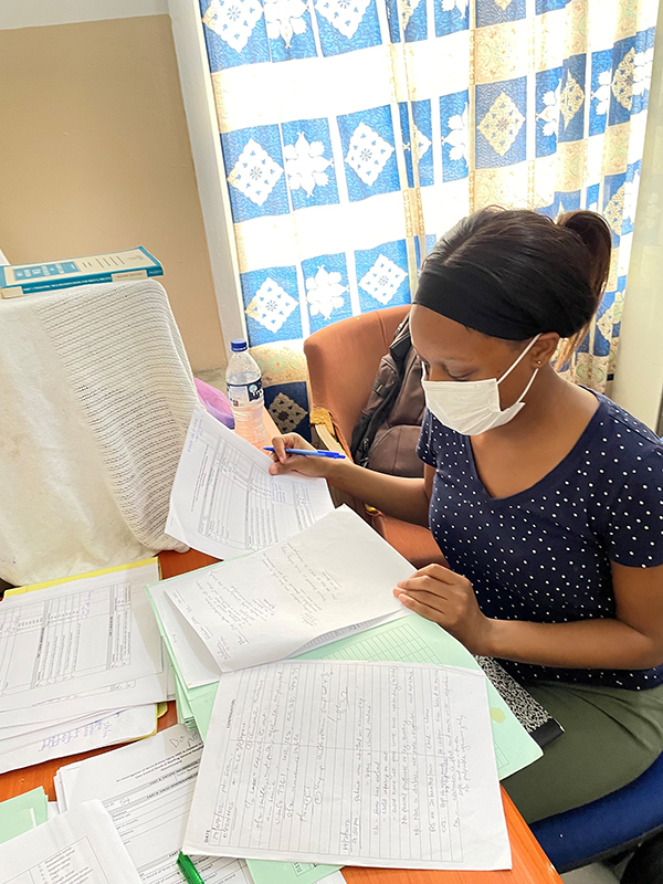 EIS officer Freddy Lamar (2022) extracts data from medical records obtained at a local hospital investigation in The Gambia.