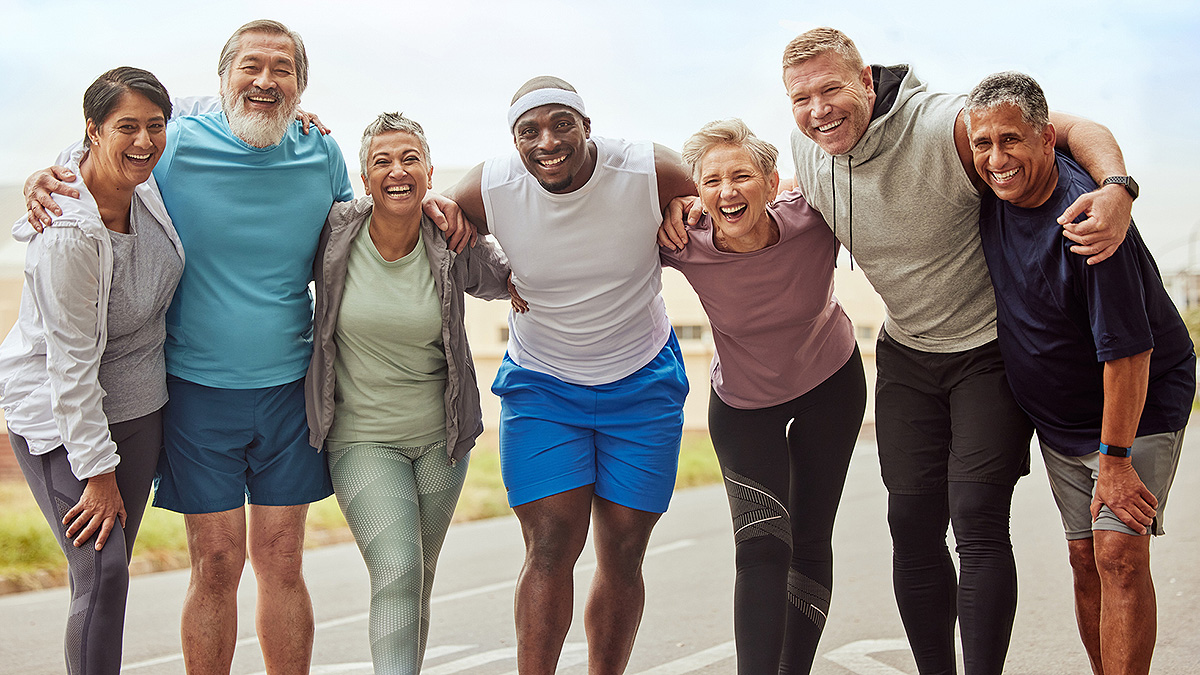 EWB Group Road Run Diverse group of seven adults posing with arms around each other after a run.