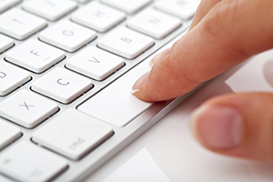 laptop keyboard with finger pressing on spacebar