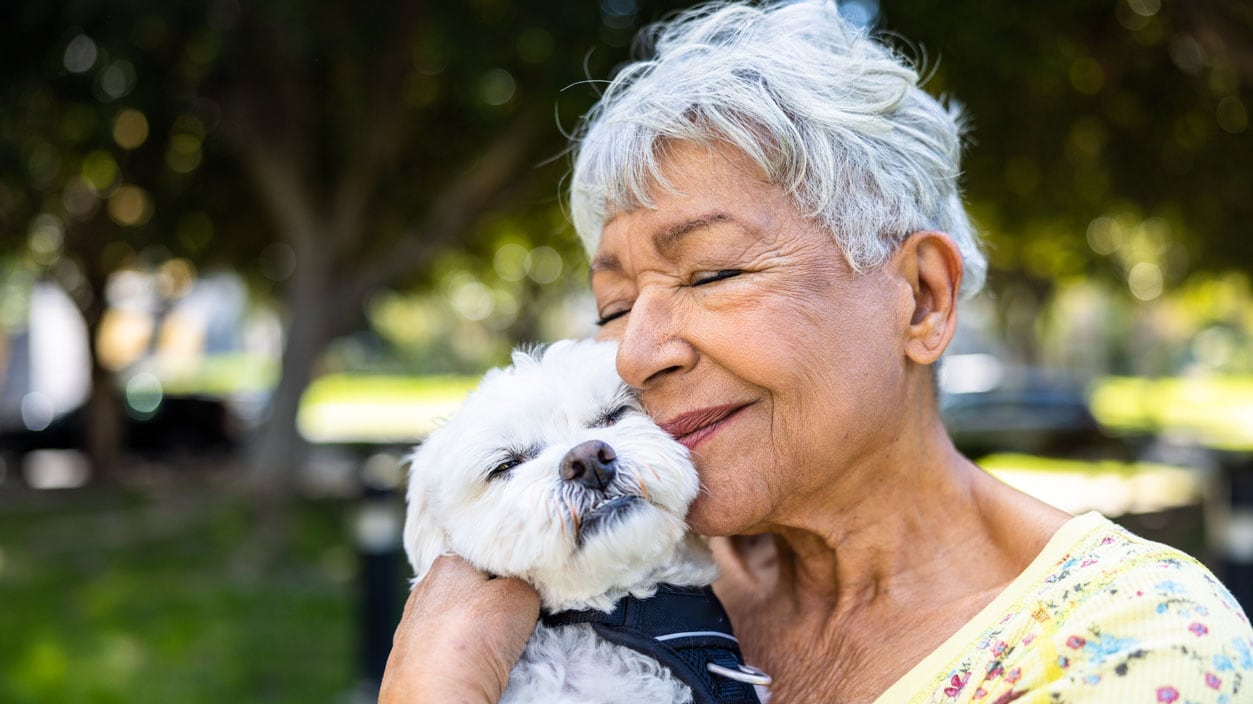 A woman holding her puppy outdoors A woman holding a puppy outdoors