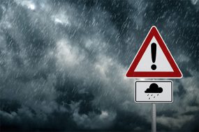 Una señal de precaución con una mala tormenta en el fondo