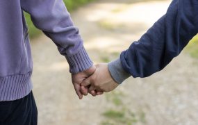 Una foto de una pareja caminando y tomados de la mano