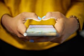  Una mujer enviando mensajes de texto en un teléfono.