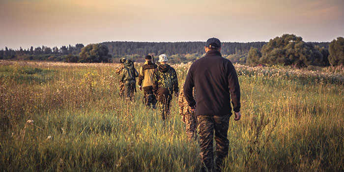 Avoid Ticks While Hunting Group of hunters walking through open field