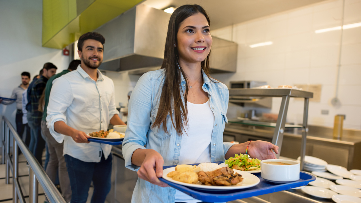Female and male in food service line at cafeteria.