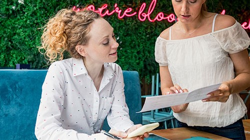Two women observing a menu.