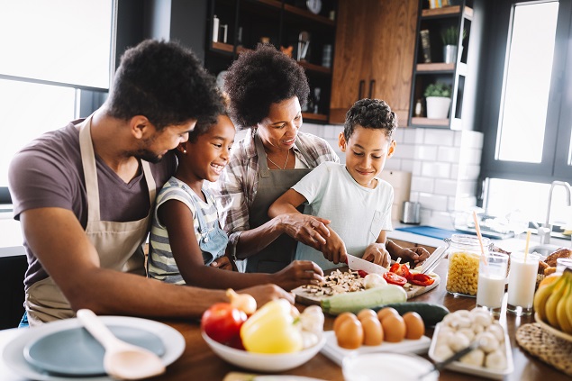 Happy african american family preparing healthy food together in kitchen Happy african american family preparing healthy food together in kitchen