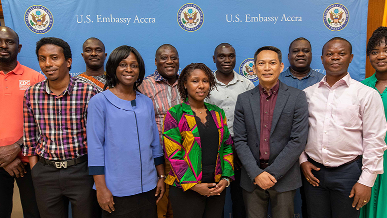 Ghana Group Photo A group of 11 people pose in front of a blue U.S. Embassy Accra banner.