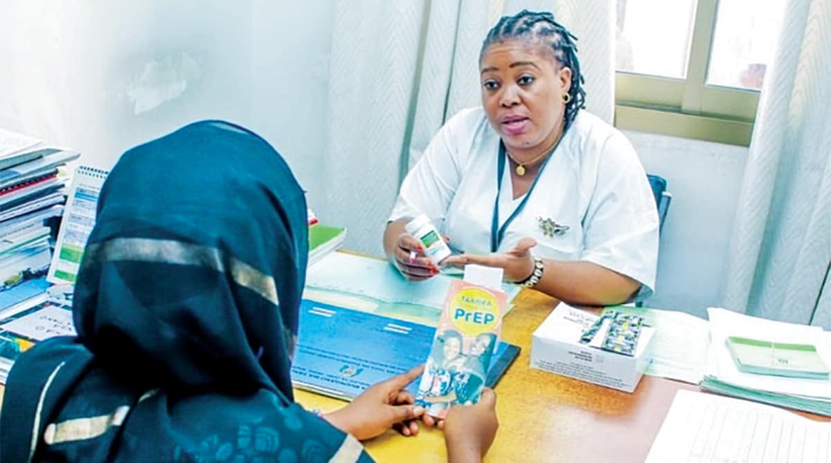 HIV_Prevention_Tanzania In Tanzania, a health care worker presents PreP information to woman. Both women are sitting in an office across a desk.