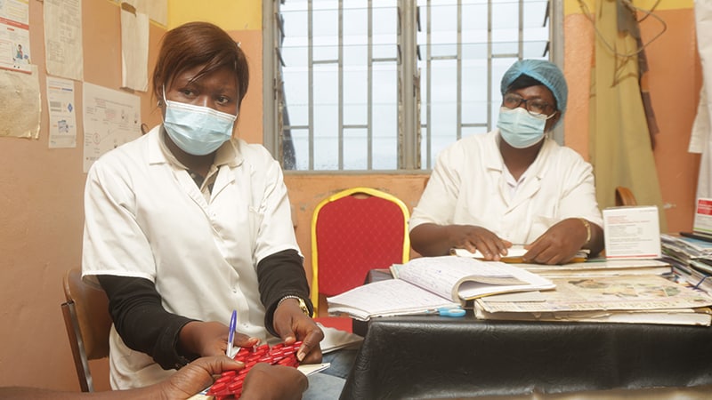 CDC supports Cameroon to ensure delivery of quality HIV/TB during COVID-19_005 Two health care workers provide HIV treatment pills