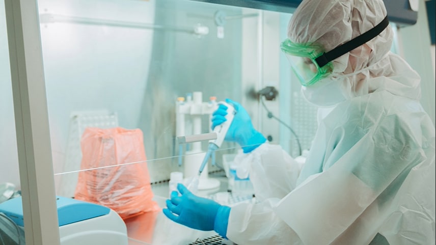 central-asia-banner-16x9 Photo of laboratorian wearing personal protective equipment with hands inside a biological safety cabinet, holding a pipette and container. Photo by Maxim Malov.