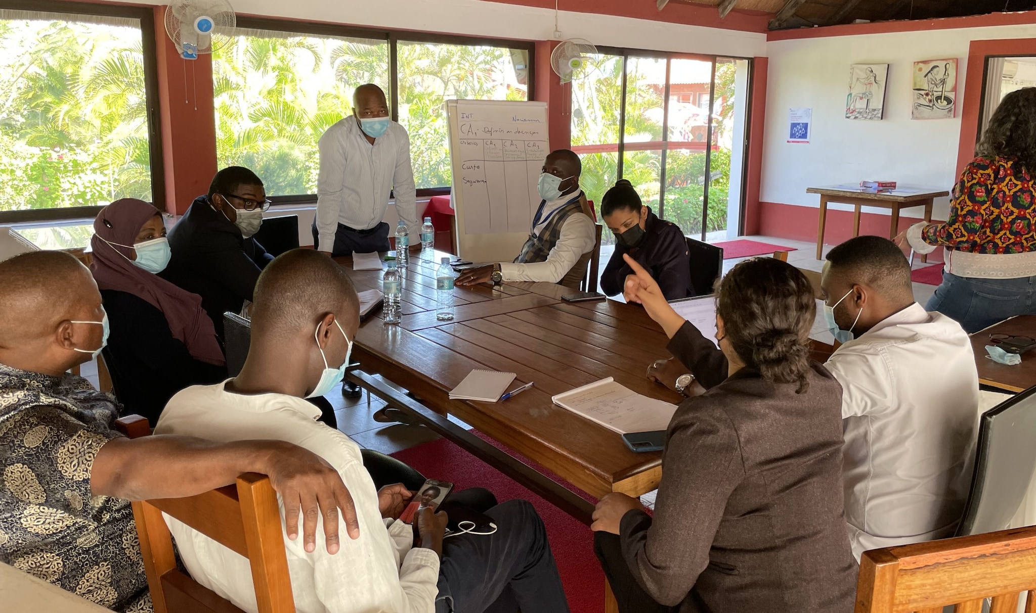 A brakout group sitting at a table discussing strategy using a whiteboard for notes